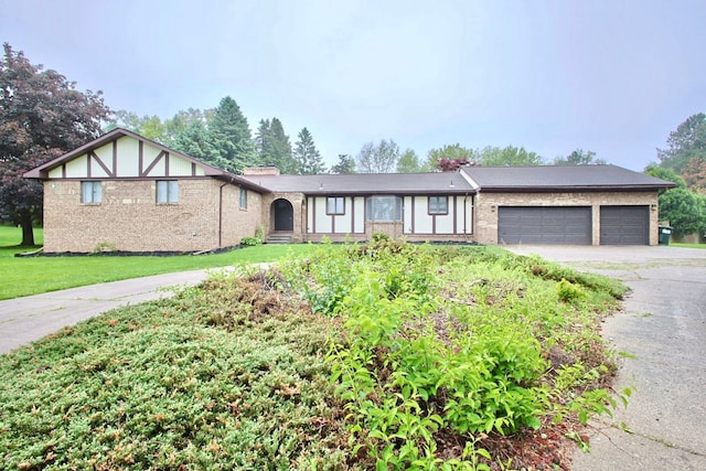 59663 Pettengill Dr, New Hudson, MI 48165 - view of front facade with asphalt driveway, an attached garage, brick siding, and a front yard