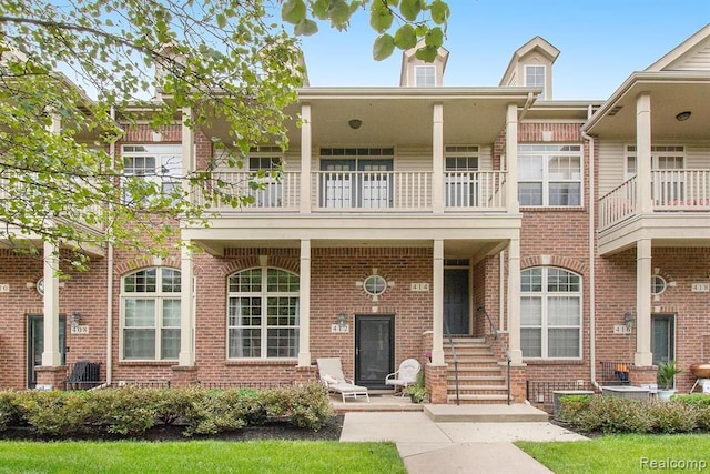 view of front of house with a balcony and brick siding