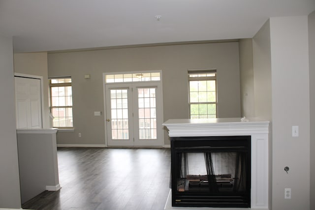 414 Old Pine Way Unit 136, Walled Lake, MI 48390 - unfurnished living room with a multi sided fireplace, dark wood-style flooring, and baseboards