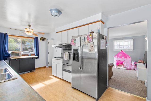 kitchen with stainless steel appliances, a warming drawer, light wood-style flooring, and white cabinetry