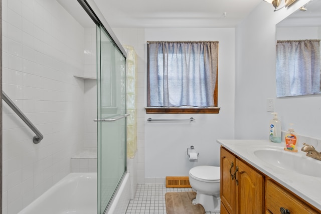 full bathroom featuring vanity, tile patterned flooring, enclosed tub / shower combo, toilet, and baseboards