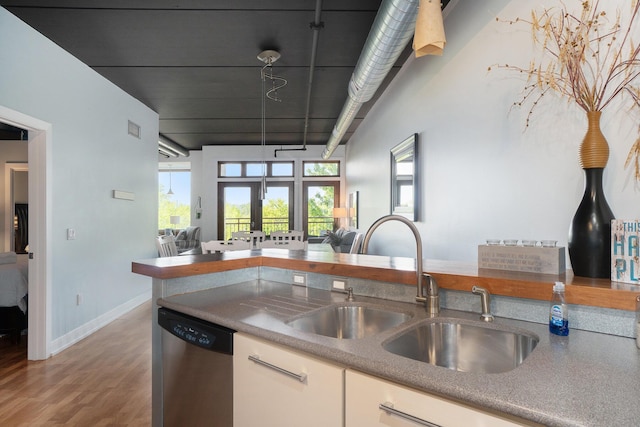 12 Washington Ave Unit 8, Grand Haven, MI 49417 - kitchen with dishwasher, open floor plan, a sink, wood finished floors, and baseboards
