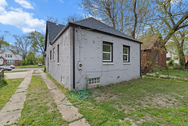 view of property exterior featuring brick siding and a shingled roof