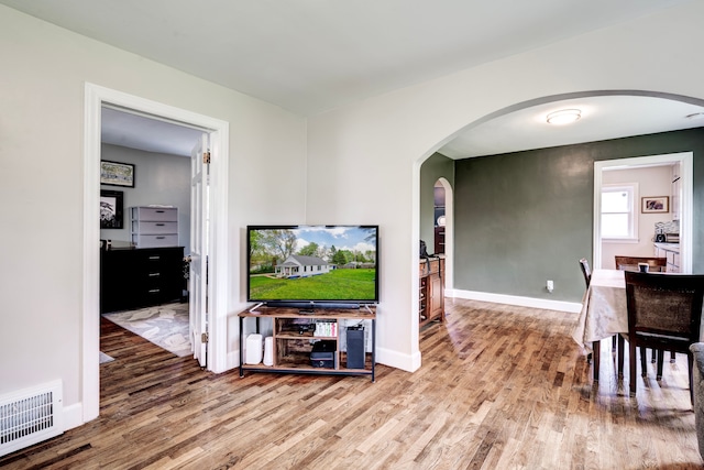 132 Jerome Ave, Ypsilanti, MI 48198 - living area with arched walkways, wood finished floors, and baseboards