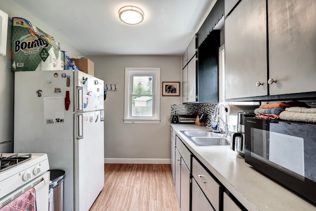 132 Jerome Ave, Ypsilanti, MI 48198 - kitchen with a sink, light countertops, light wood finished floors, white appliances, and baseboards