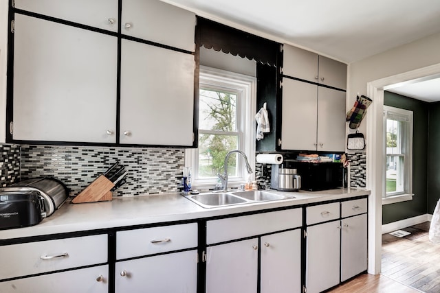 132 Jerome Ave, Ypsilanti, MI 48198 - kitchen featuring a sink, decorative backsplash, light countertops, and healthy amount of natural light