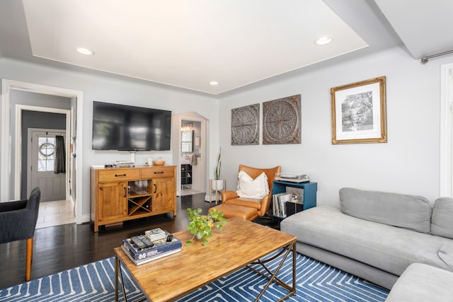 living area with arched walkways, recessed lighting, dark wood-type flooring, and baseboards