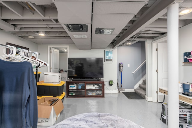 finished basement featuring stairway and baseboards