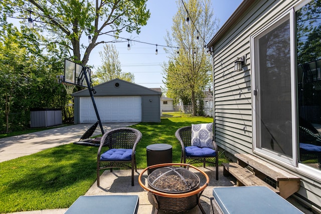 view of patio / terrace with an outdoor fire pit, an outdoor structure, and a detached garage