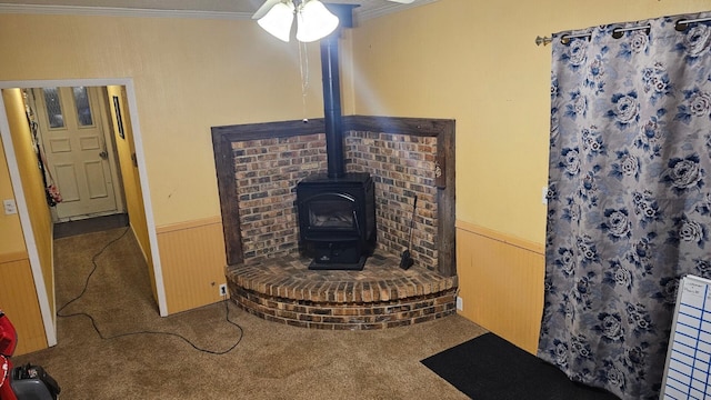 2726 Horton Ct, Niles, MI 49120 - detailed view of ornamental molding, a wood stove, a wainscoted wall, carpet, and a ceiling fan