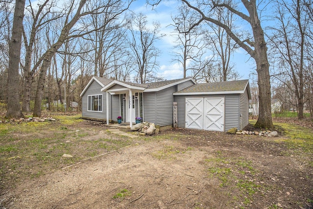 6280 Gleason Rd, Saugatuck, MI 49453 - view of front of home featuring a shingled roof, dirt driveway, and a garage