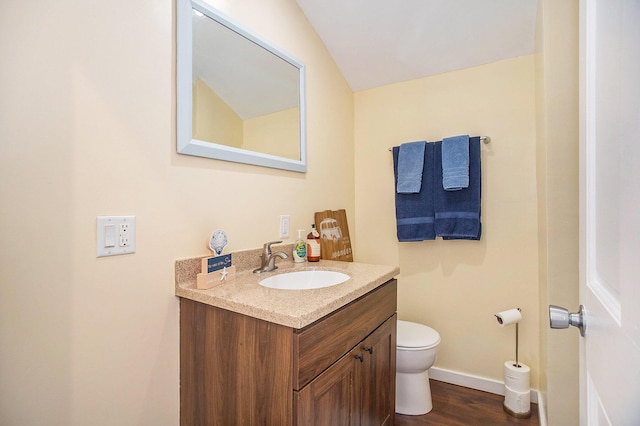 6280 Gleason Rd, Saugatuck, MI 49453 - half bathroom featuring vanity, toilet, wood finished floors, and baseboards