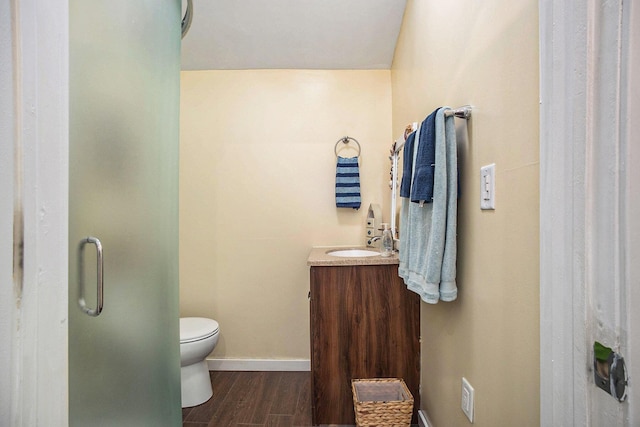 6280 Gleason Rd, Saugatuck, MI 49453 - full bath with wood finished floors, vanity, toilet, baseboards, and a stall shower