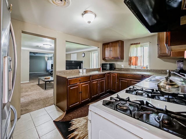 8320 Nightingale St, Dearborn Heights, MI 48127 - kitchen with stainless steel refrigerator with ice dispenser, gas range oven, light colored carpet, a sink, and range hood