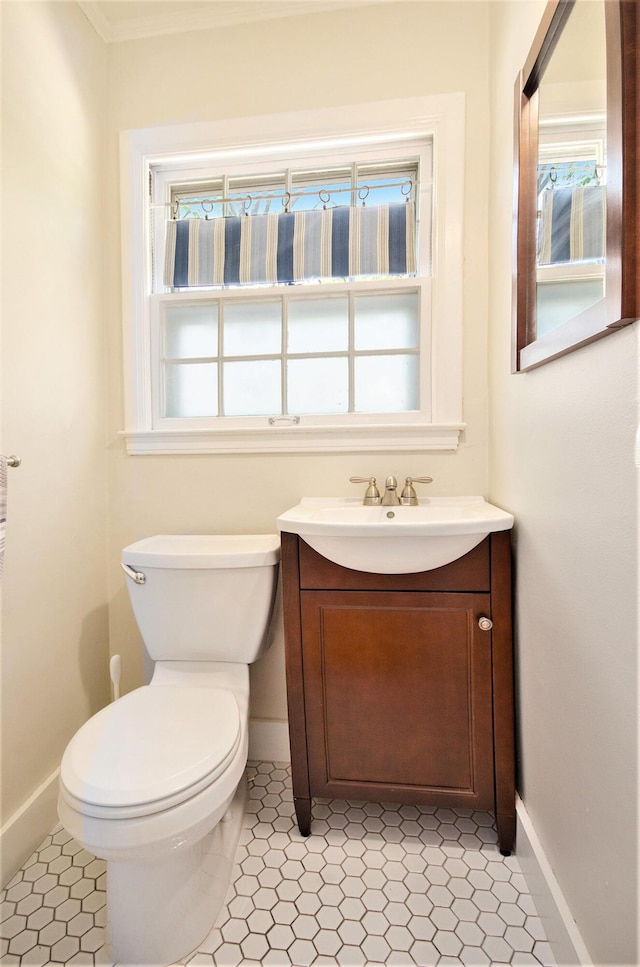 bathroom with baseboards, vanity, and toilet