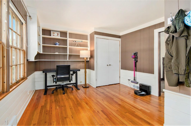 office space featuring wood-type flooring, ornamental molding, and wood walls