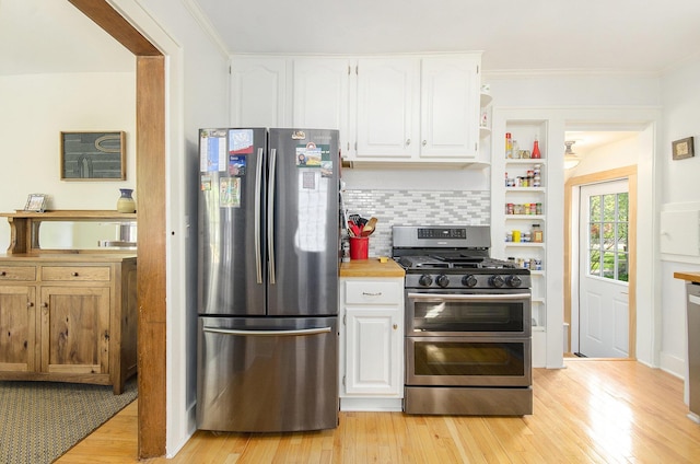 kitchen featuring appliances with stainless steel finishes, white cabinetry, light wood finished floors, open shelves, and backsplash