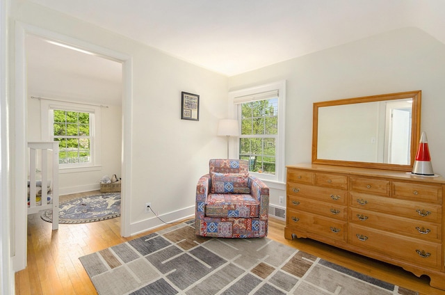 living area featuring light wood finished floors, plenty of natural light, and baseboards
