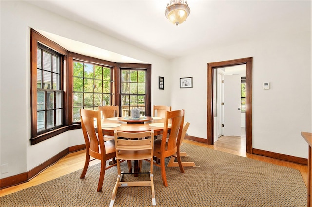 dining area with light wood-style floors and baseboards