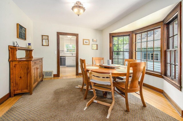 dining space featuring plenty of natural light, light wood finished floors, and baseboards