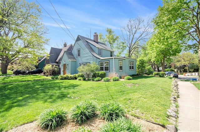 view of side of property featuring a chimney and a yard