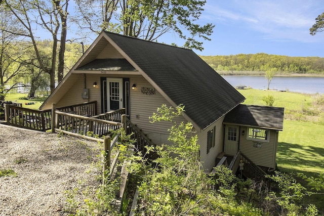 9458 Edwin Markham Rd, Brooklyn, MI 49230 - view of side of home with roof with shingles, a lawn, and a deck with water view