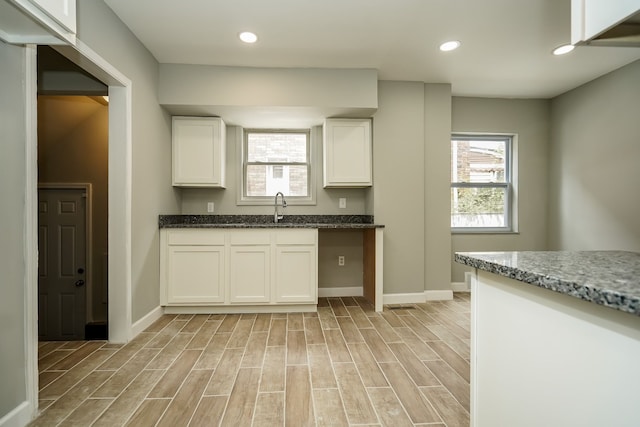 17344 Wisconsin St, Detroit, MI 48221 - kitchen with baseboards, light wood-style floors, a sink, white cabinetry, and recessed lighting