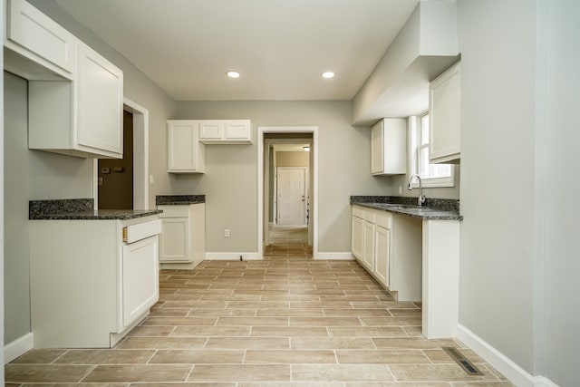 17344 Wisconsin St, Detroit, MI 48221 - kitchen with a sink, baseboards, dark stone countertops, recessed lighting, and white cabinetry