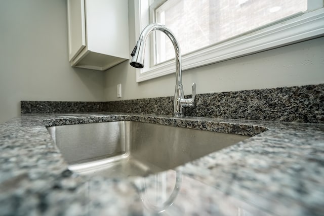 17344 Wisconsin St, Detroit, MI 48221 - kitchen view of a sink, white cabinets, and dark stone countertops