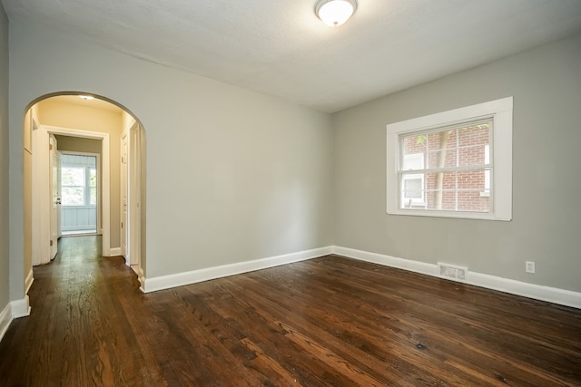 17344 Wisconsin St, Detroit, MI 48221 - unfurnished room featuring arched walkways, dark wood-type flooring, and baseboards