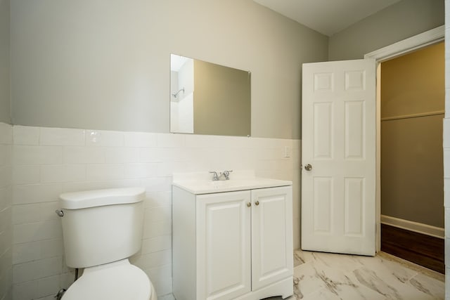 17344 Wisconsin St, Detroit, MI 48221 - bathroom with marble look tiles, toilet, vanity, and a wainscoted wall