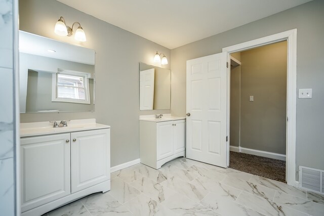 17344 Wisconsin St, Detroit, MI 48221 - full bath with two vanities, baseboards, and marble look tiles