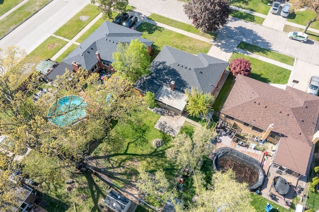 aerial view of property and surrounding area featuring nearby suburban area and a pool