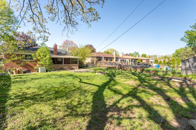 view of yard featuring a sunroom and central air condition unit