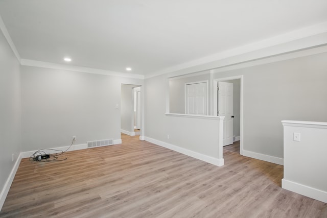 empty room with baseboards, crown molding, light wood-style flooring, and recessed lighting