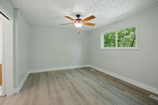 unfurnished room with light wood-style floors, ceiling fan, and baseboards