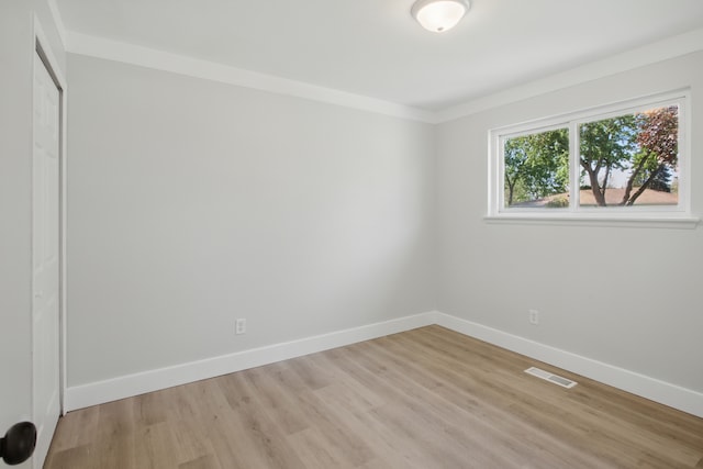 unfurnished room with baseboards and light wood-type flooring