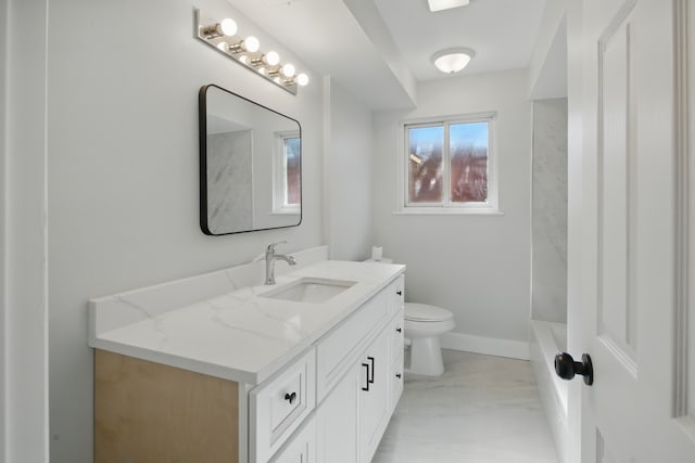 full bath with toilet, vanity, marble look tiles, a tub to relax in, and baseboards