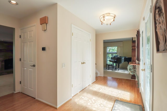 hallway with light wood-style flooring, baseboards, and recessed lighting