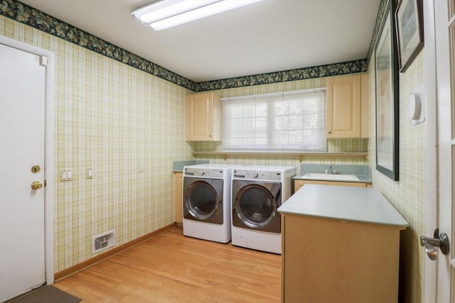 laundry room featuring wallpapered walls, cabinet space, washing machine and dryer, light wood-type flooring, and baseboards