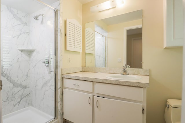 bathroom featuring a marble finish shower, vanity, and toilet