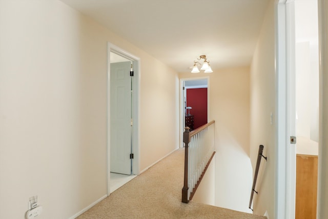 corridor featuring an upstairs landing and carpet flooring