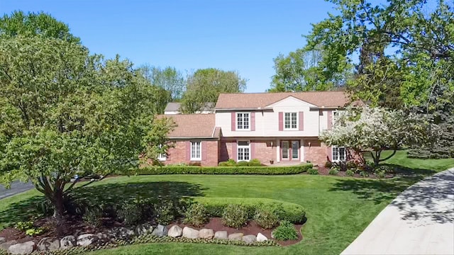 view of front of home featuring a front yard and brick siding