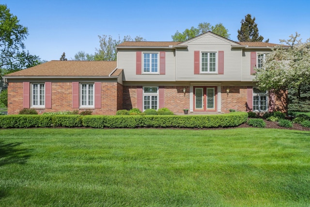 view of front facade featuring brick siding and a front yard