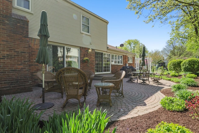 back of property with a patio and brick siding