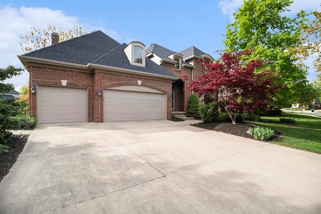 24391 Cavendish Ave E, Novi, MI 48375 - french country style house featuring brick siding, a garage, concrete driveway, a chimney, and a shingled roof