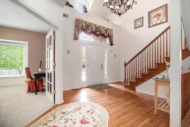 24391 Cavendish Ave E, Novi, MI 48375 - foyer with plenty of natural light, a chandelier, wood finished floors, and a towering ceiling
