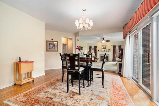 24391 Cavendish Ave E, Novi, MI 48375 - dining room featuring light wood-style floors, a chandelier, ceiling fan, and baseboards