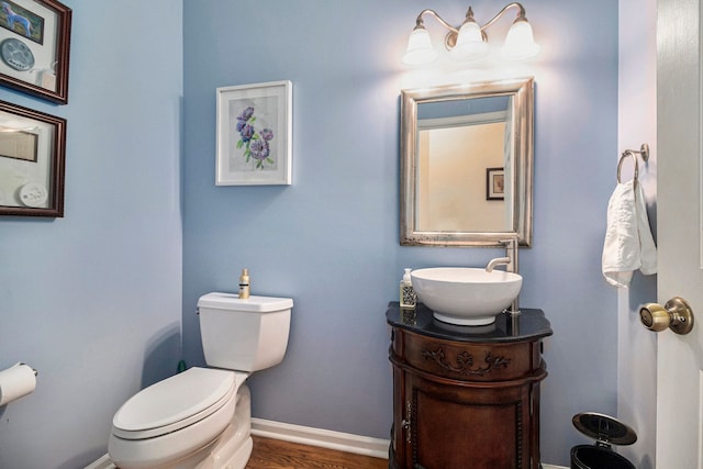 24391 Cavendish Ave E, Novi, MI 48375 - half bathroom with toilet, baseboards, vanity, and wood finished floors