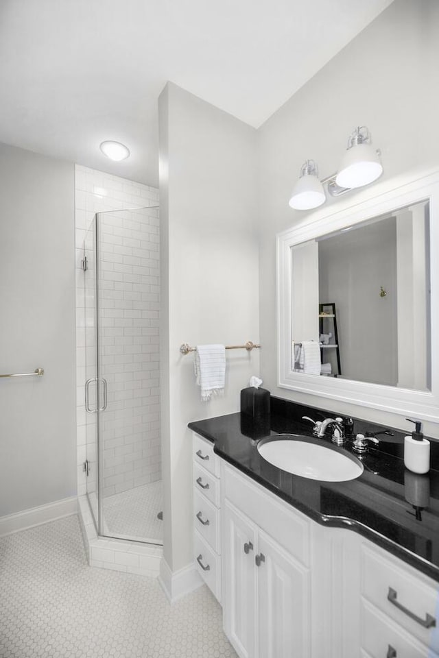 bathroom featuring a stall shower, vanity, baseboards, and tile patterned floors